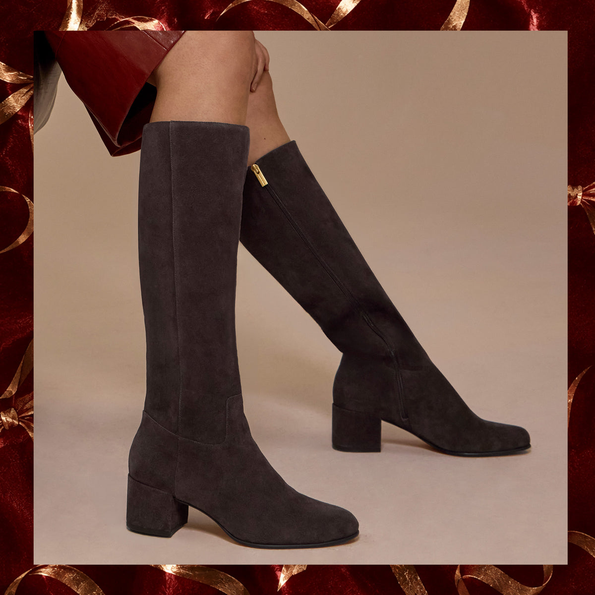 brown suede boots on a tan background with a red and gold border