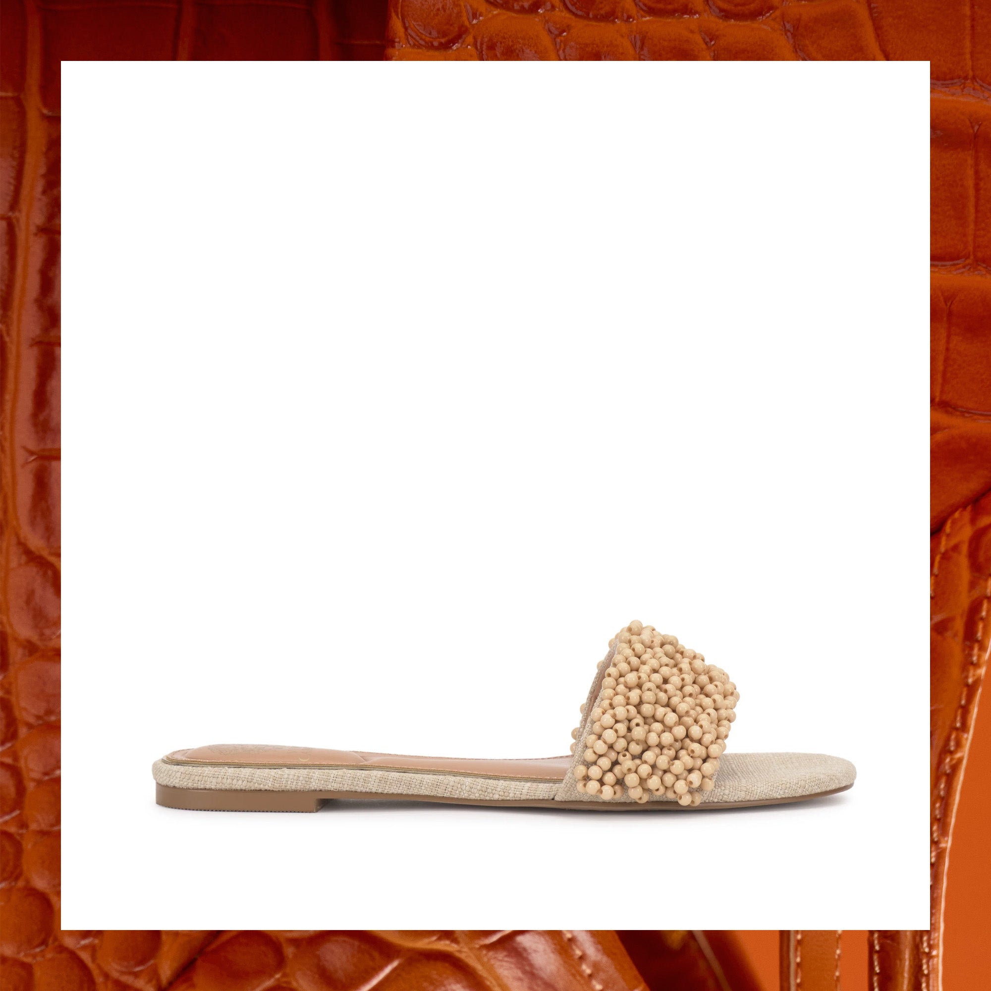 Beige sandal with bead embellishments on a white background