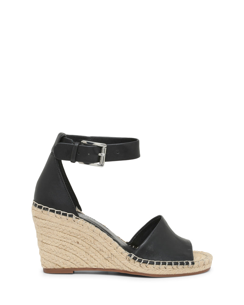 The Vince Camuto Leera Espadrille Wedge Sandal is a black open-toe shoe with an ankle strap and buckle, showcasing a woven espadrille-style platform heel and a brown sole, displayed in side profile.