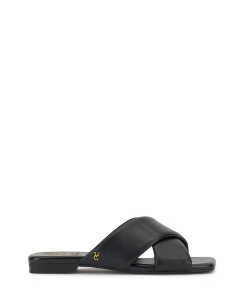 The Vince Camuto Adisey Cross-Band Sandal is a black flat slide with wide crisscross straps and a small gold logo on the side, ideal for daily wear. Shown in side profile on a white background.