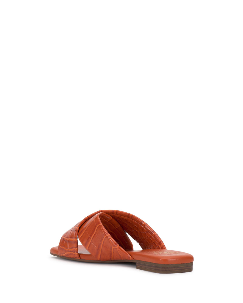 The Vince Camuto Adisey Cross-Band Sandal features orange crocodile-textured crisscross straps and a low brown heel, shown from the back at an angle on a white background.