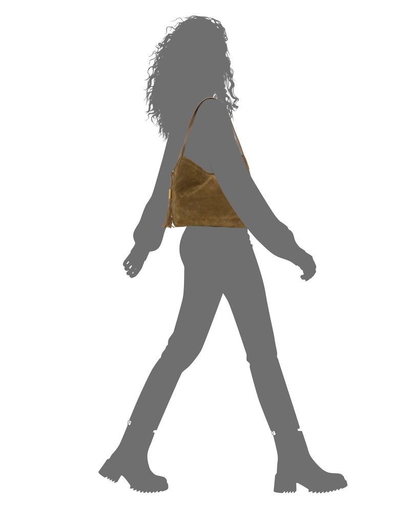 A silhouette of a person walking, wearing boots and carrying the Aleah Shoulder Bag by Vince Camuto—a perfect fall bag in brown suede.