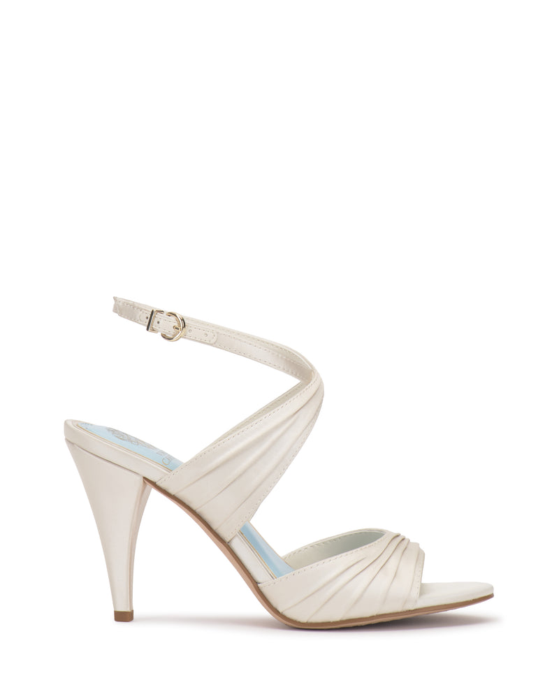 Altnori Sandal by Vince Camuto in ivory features an ankle strap, open toe, and pleated detailing on the front and sides, shown on a white background.