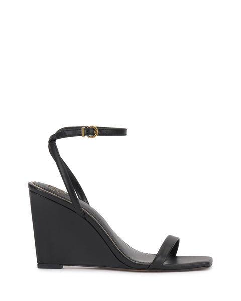 The Vince Camuto Ambee Wedge Sandal features a black, open square toe with a single front strap and ankle strap with gold buckle. Its high solid wedge heel and minimalist design make it ideal for formal occasions.