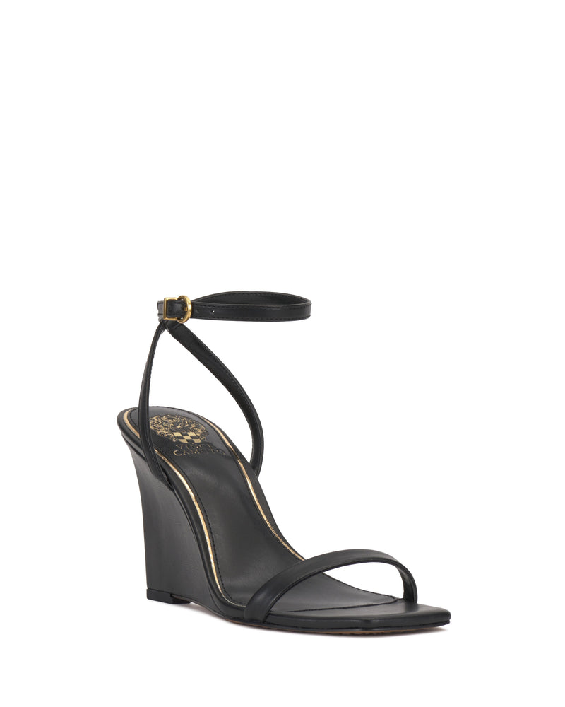 The Vince Camuto Ambee Wedge Sandal features a black square toe, thin toe strap, ankle strap with small buckle, and gold insole detailing for added elegance—perfect for formal occasions.