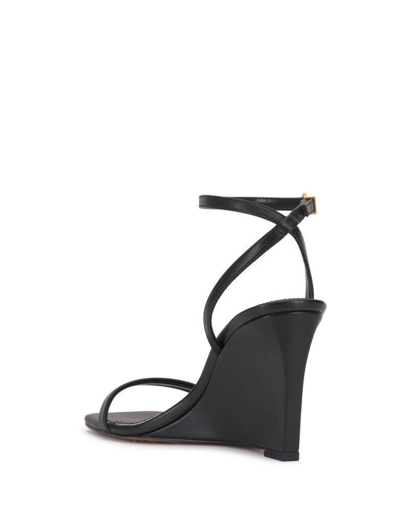 The Vince Camuto Ambee Wedge Sandal features a black high wedge heel, square toe, thin ankle strap with gold buckle, and minimalist toe strap—its sleek solid design is ideal for formal occasions.