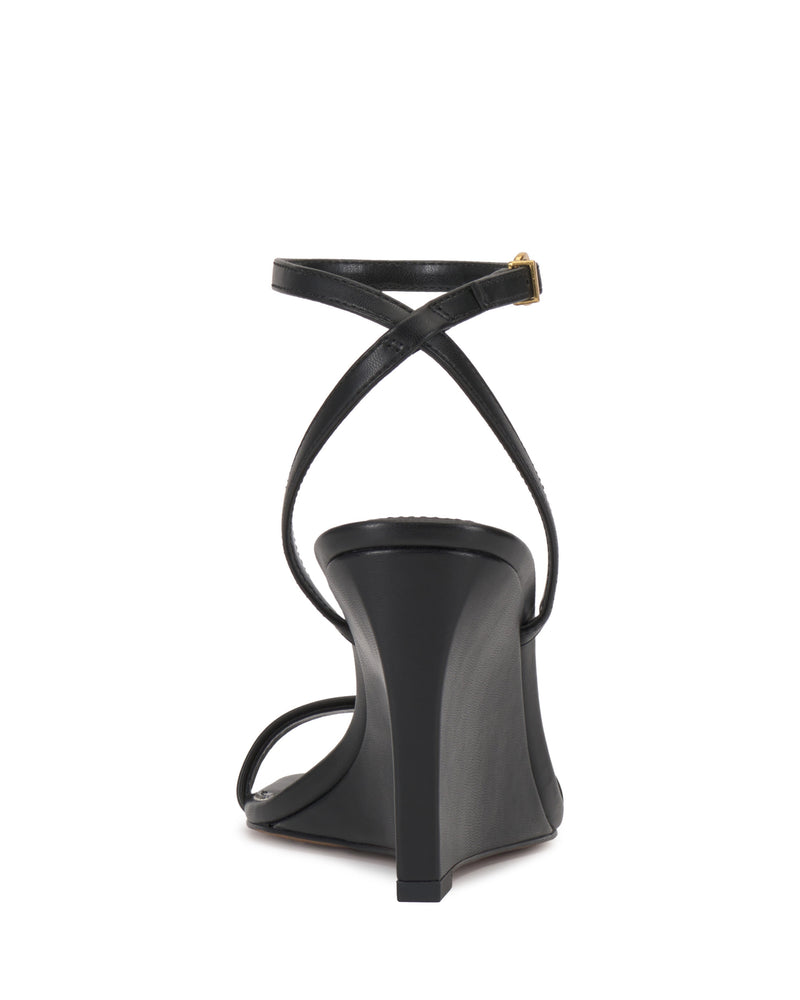 Back view of the Vince Camuto Ambee Wedge Sandal in black, featuring a square toe, crisscross ankle strap with gold buckle, and a sleek, minimalist design—ideal for formal occasions.