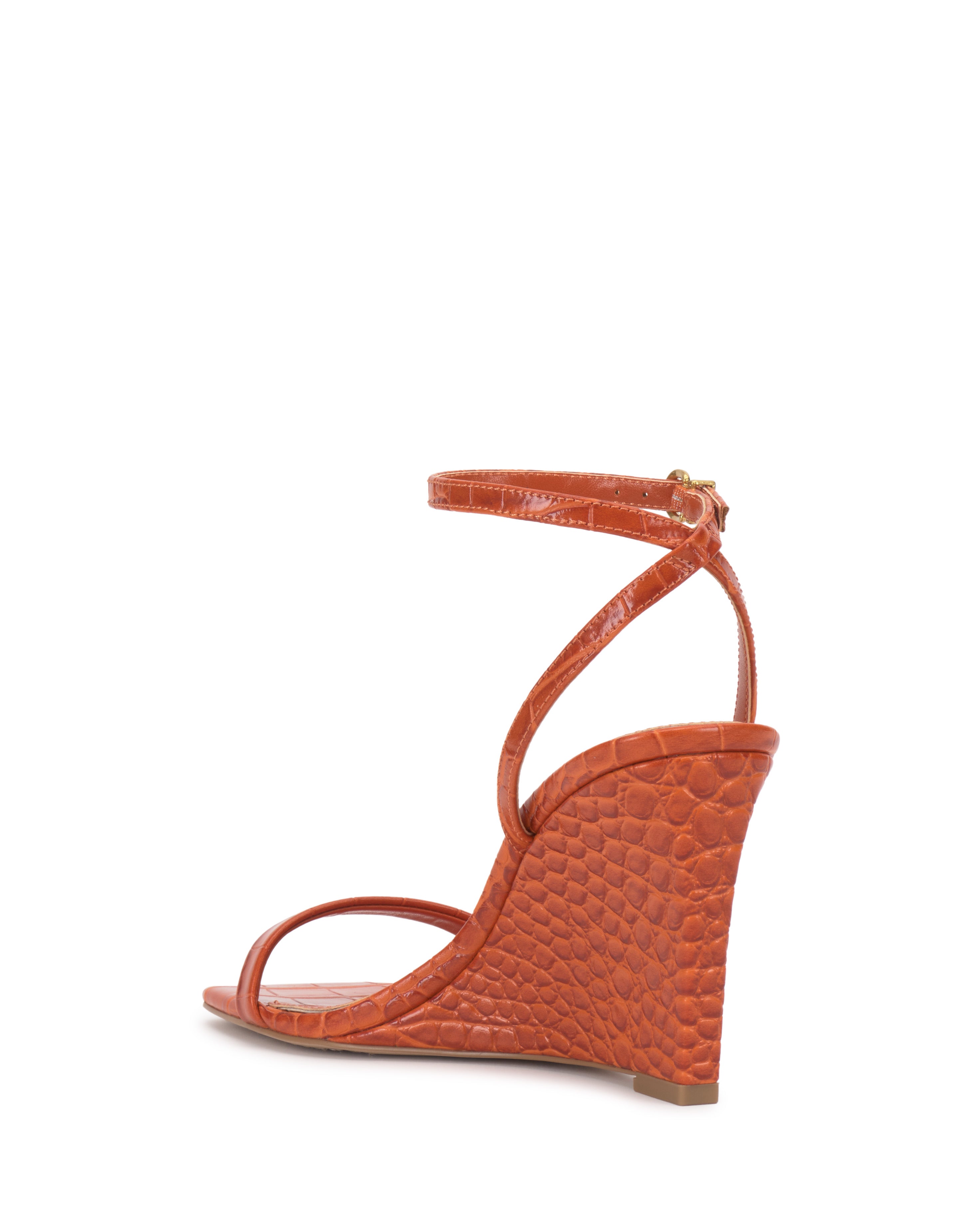 Side view of the Ambee Wedge Sandal by Vince Camuto—an orange wedge with a crocodile-textured surface, square toe, and ankle strap with a small gold buckle—perfect for formal occasions.