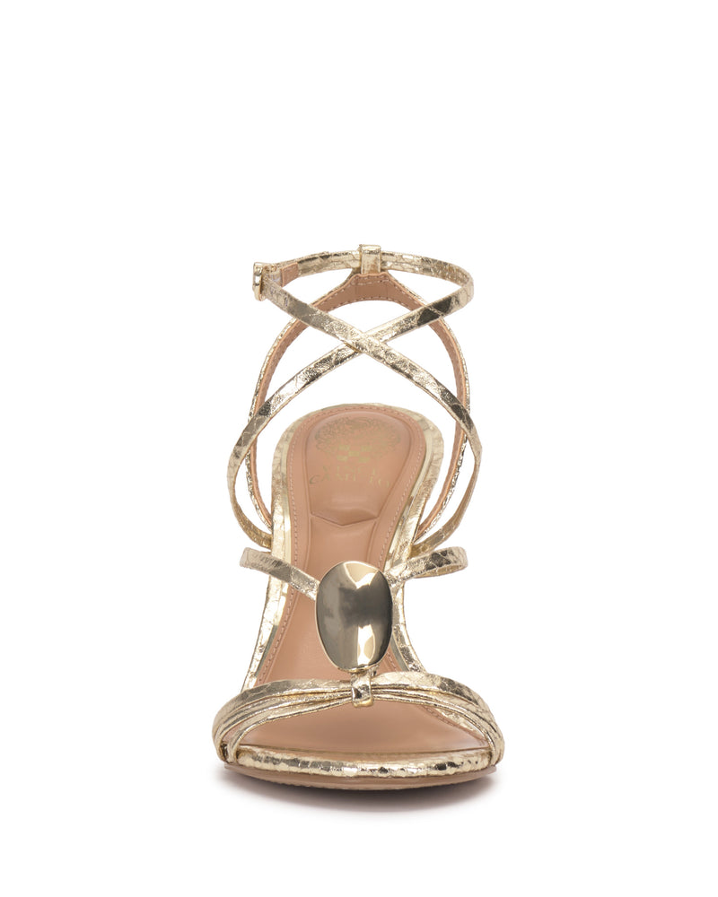 The Vince Camuto Arlein Sandal in gold showcases a sharp heel, crisscross ankle straps, and a large gemstone on the toe strap—a dazzling choice for any glamorous night out.