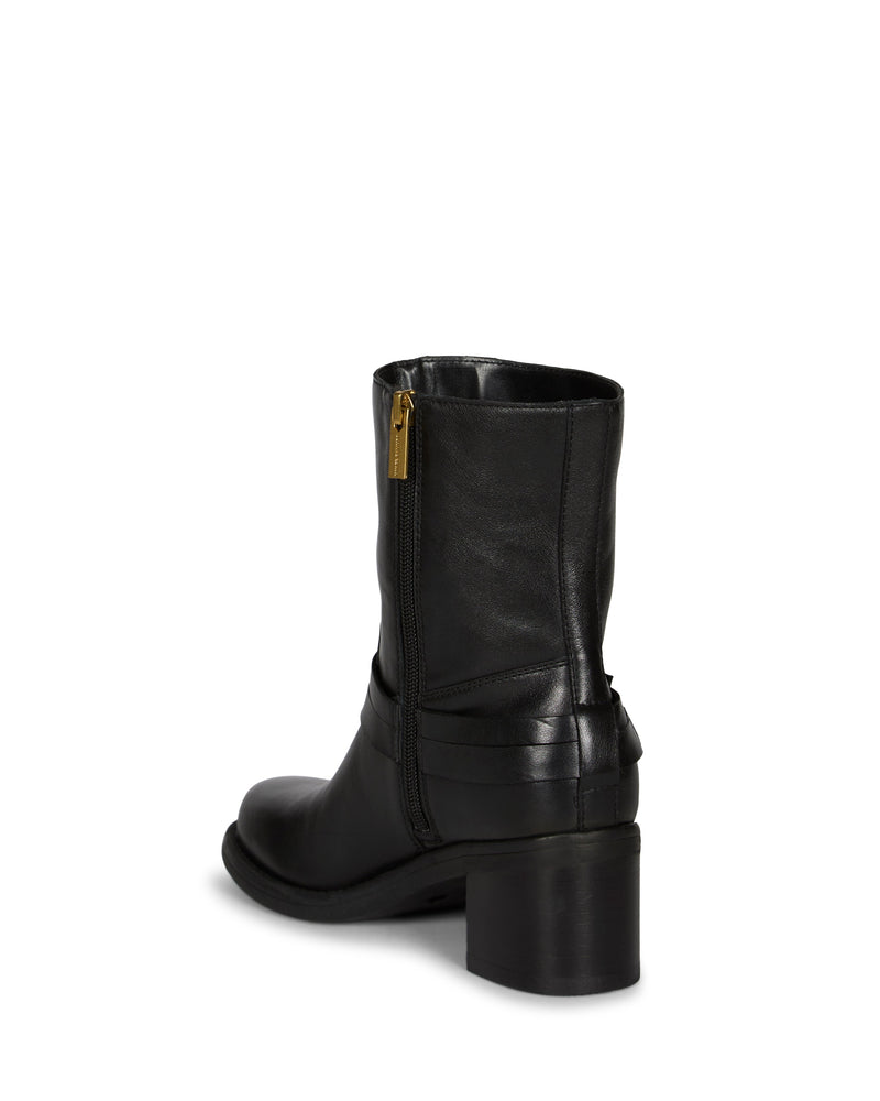 The Vince Camuto Armia Bootie is shown on a white background from a rear angle, featuring black leather construction, a chunky block heel, side zipper closure, and a subtle strap detail at the back.
