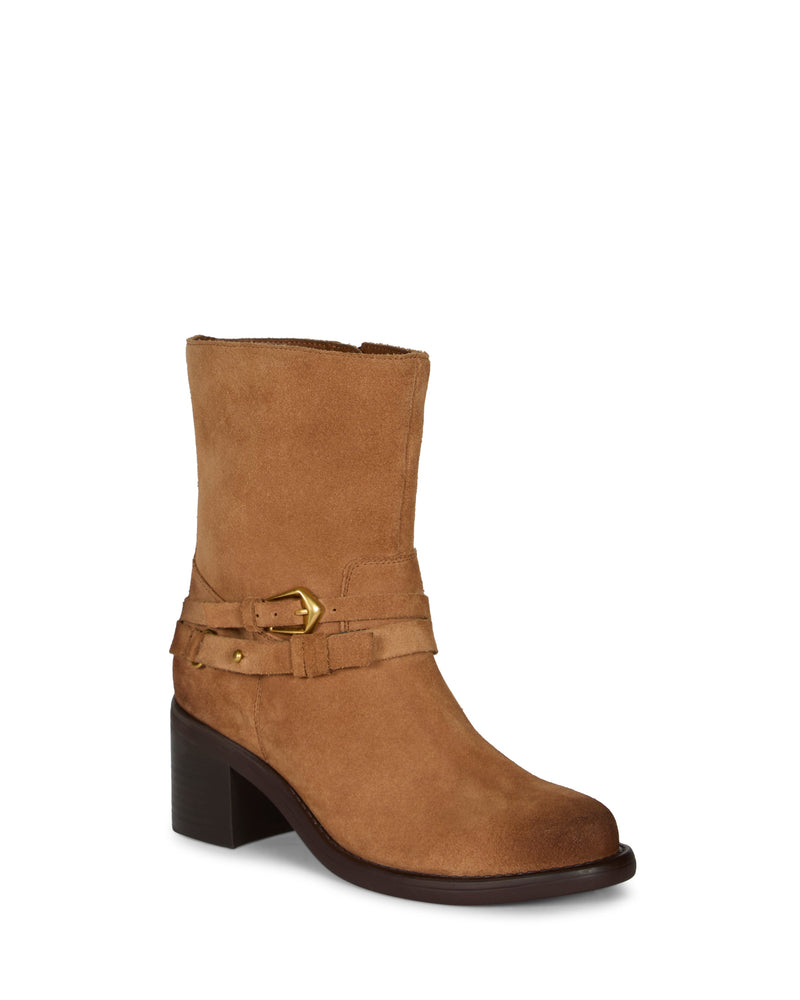 The Vince Camuto Armia Bootie is a tan suede mid-calf boot featuring a low block heel, decorative leather straps, and gold buckle detailing with a subtle harness accent, displayed on a white background.