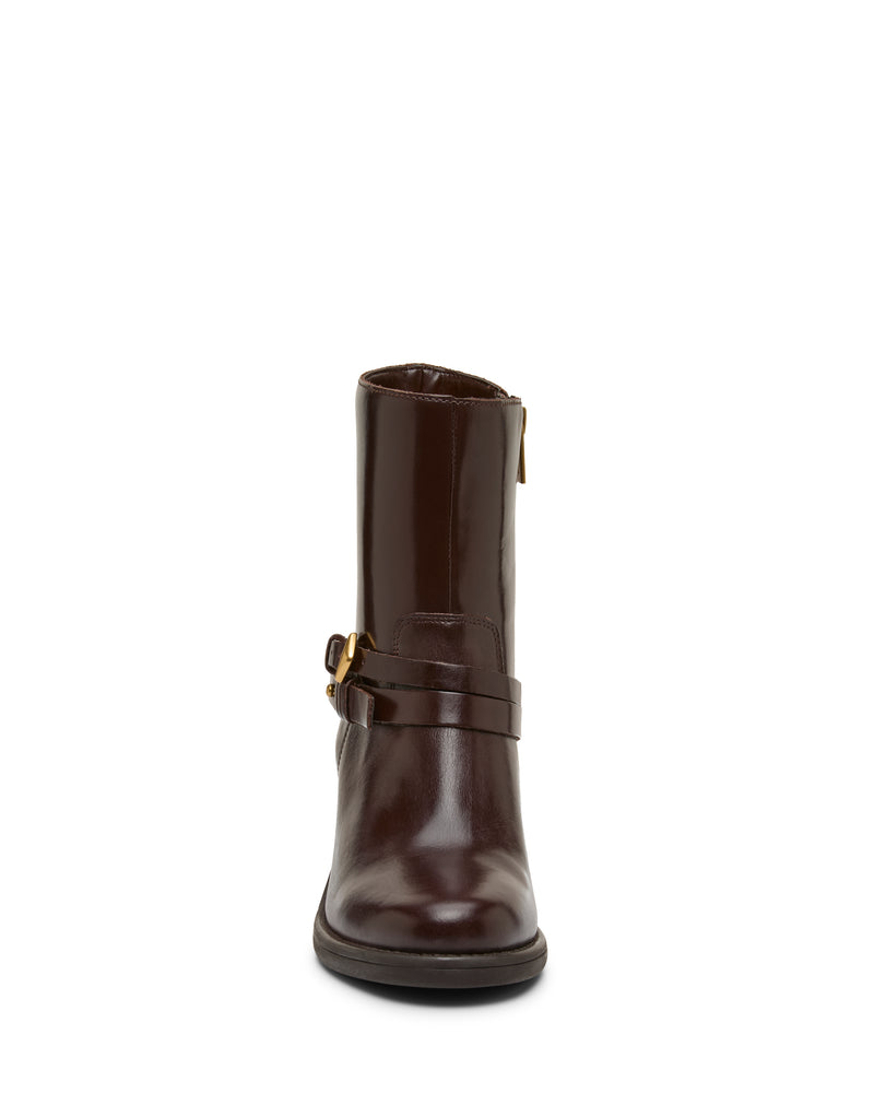 Front view of a single Vince Camuto Armia Bootie in dark brown leather, showcasing a strap with gold buckle harness detail, low block heel, rounded toe, and side zipper. The background is plain white.