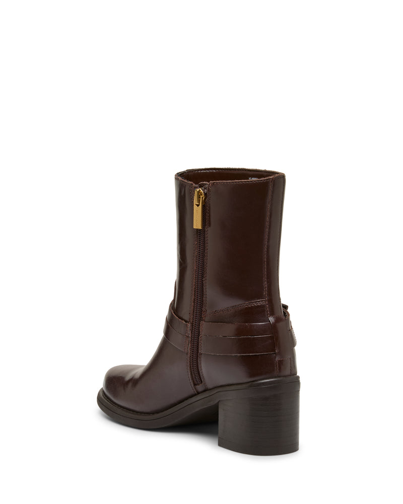 The Vince Camuto Armia Bootie is a brown leather ankle bootie with a chunky block heel, side zipper, and a decorative strap detail featuring a subtle buckle harness, displayed from the back angle on a white background.