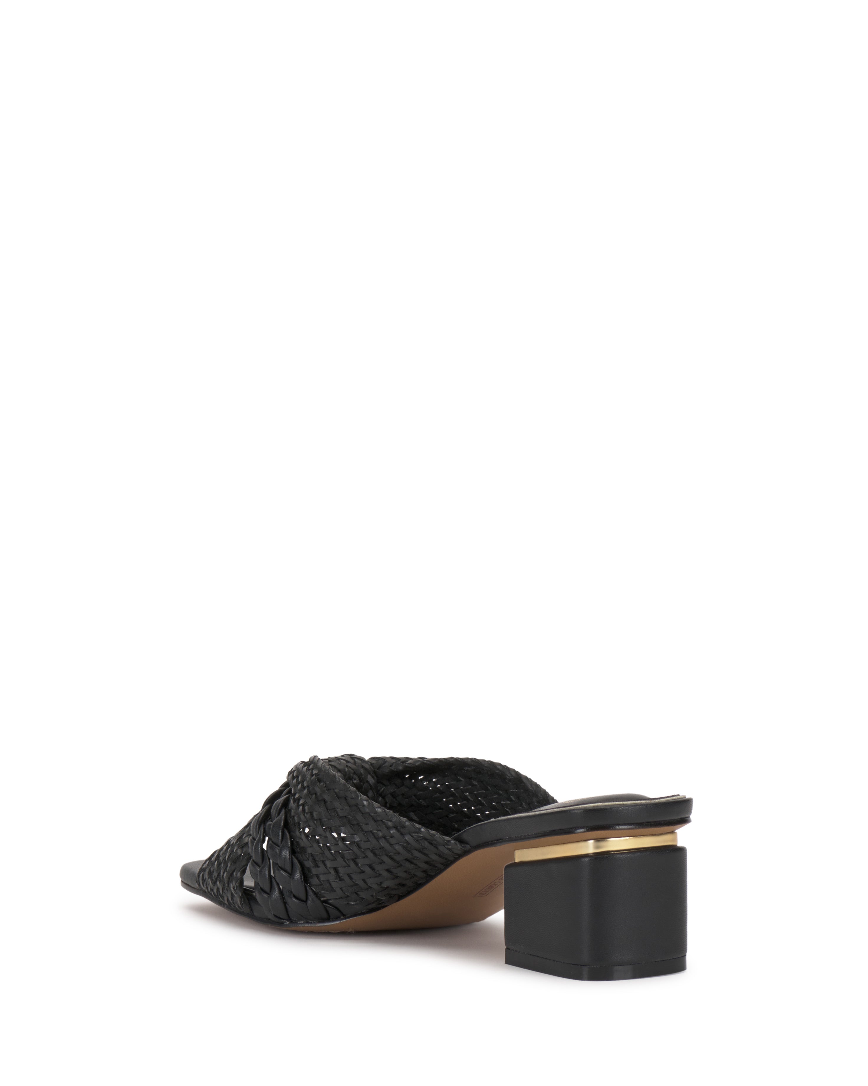 The Atemly Knotted Sandal by Vince Camuto is a black mule with woven details, an open back, and a low block heel with a gold accent near the sole. The shoe is angled to show both side and back views.