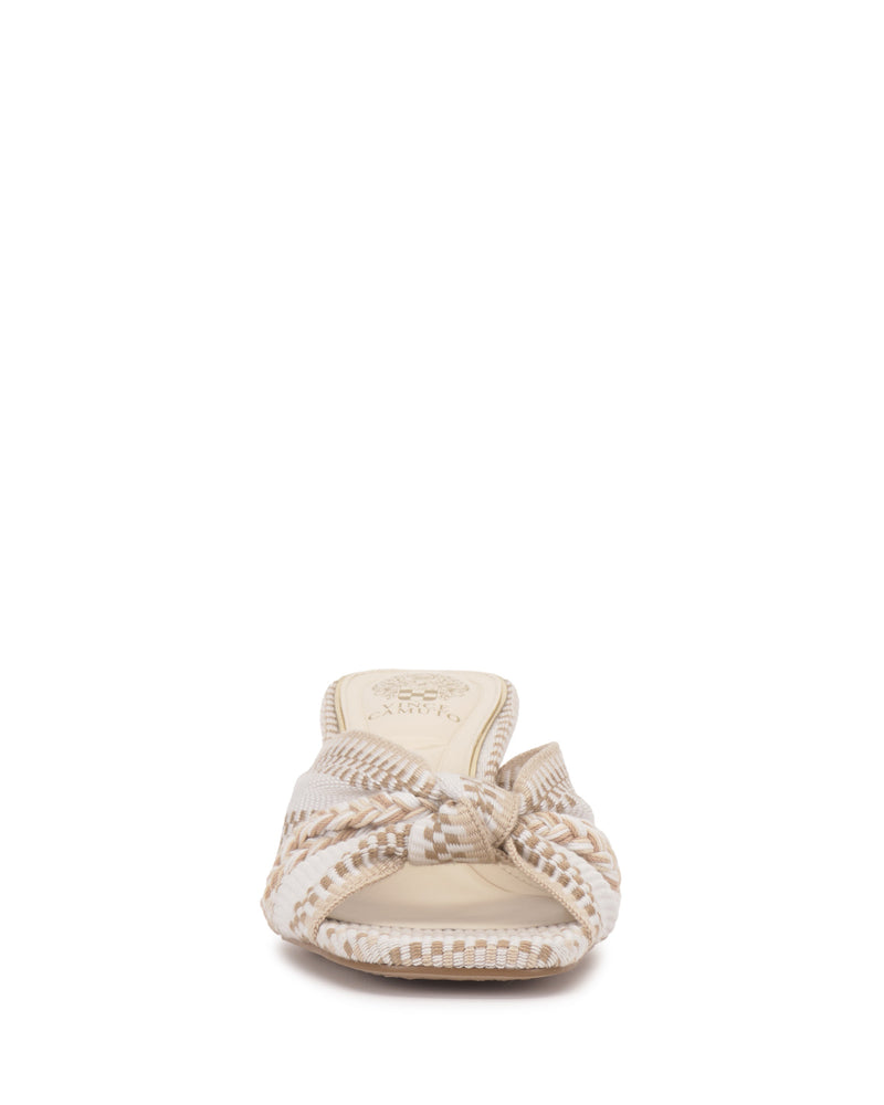The Atemly Knotted Sandal by Vince Camuto features a beige and white woven upper with a knotted design, open toe, patterned insole, and brand logo—ideal for a bohemian look.
