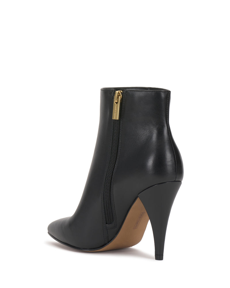 The Vince Camuto Attiza Bootie is a black leather ankle bootie with a pointed toe, high stiletto heel, side zipper, and tan sole, shown from the back-right angle.