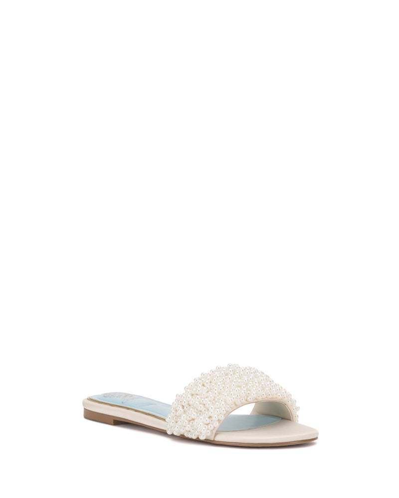 The Balea Beaded Sandal by Vince Camuto features a light beige sole, an open toe, and a wide strap adorned with elegant white pearl beading for a minimalist, sophisticated look.