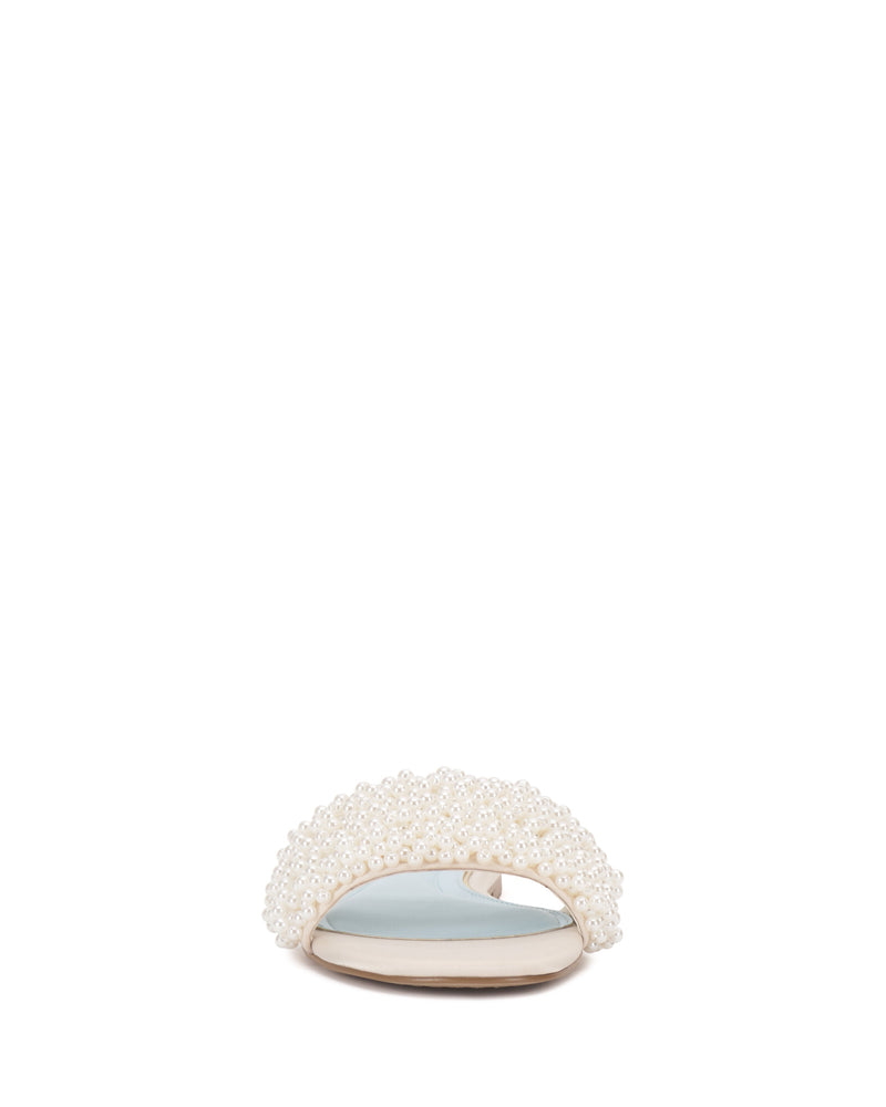 The Balea Beaded Sandal by Vince Camuto is a white open-toe flat featuring elegant beadwork, shown front-facing on a plain white background—ideal versatile footwear for any occasion.