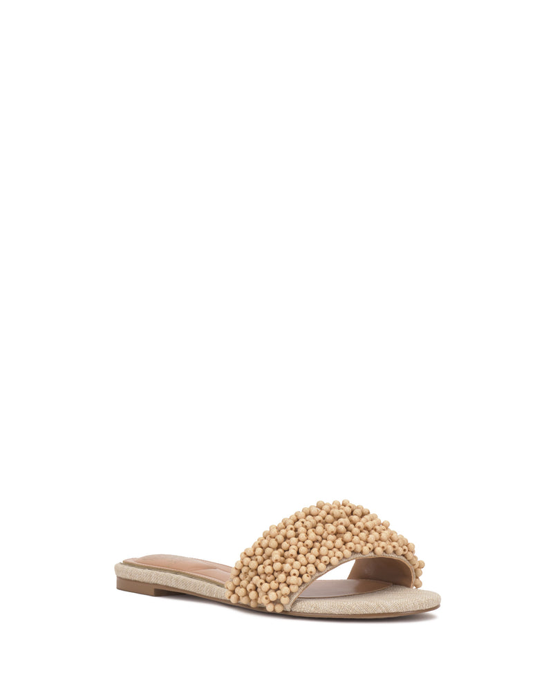 The Vince Camuto Balea Beaded Sandal features a beige flat design with a single wide strap accented by clustered round beads, offering stylish versatility. Perfect for effortless elegance, shown here on a white background.