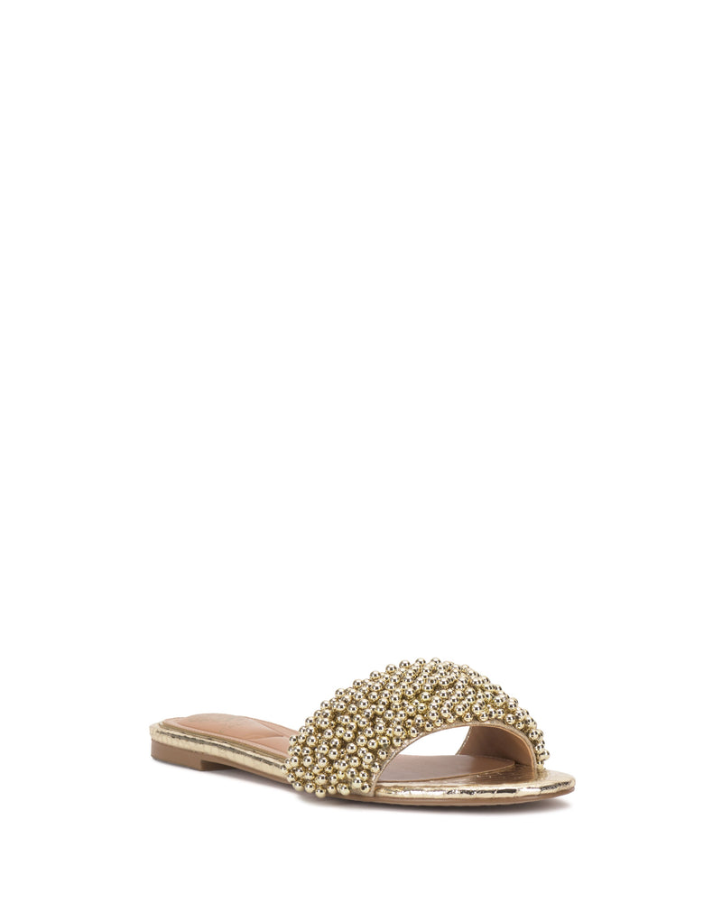 The Balea Beaded Sandal by Vince Camuto is a gold flat with an open toe and an embellished, beaded strap, shown against a white background.