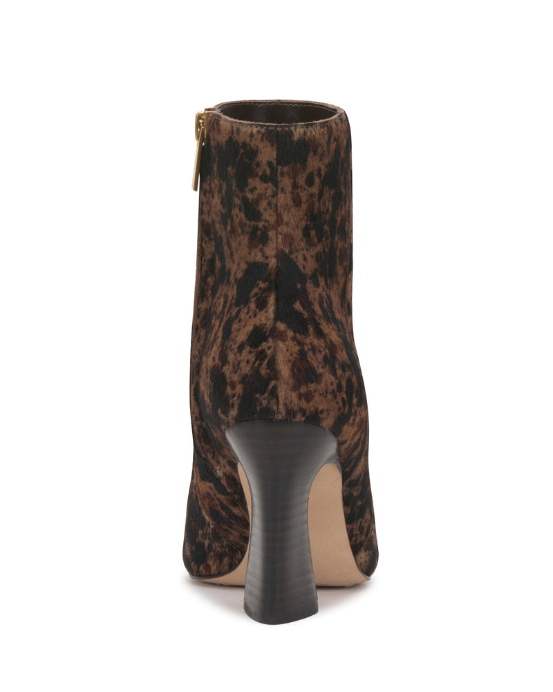 A rear view of the Vince Camuto Bayla Bootie showcases its brown and black patterned design, curved block heel, and back zipper closure.