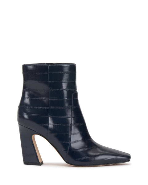 The Bayla Bootie by Vince Camuto is a navy blue, high-heeled ankle bootie featuring a pointed toe and subtle horizontal textured lines, displayed in profile on a white background, and exemplifying effortless style.