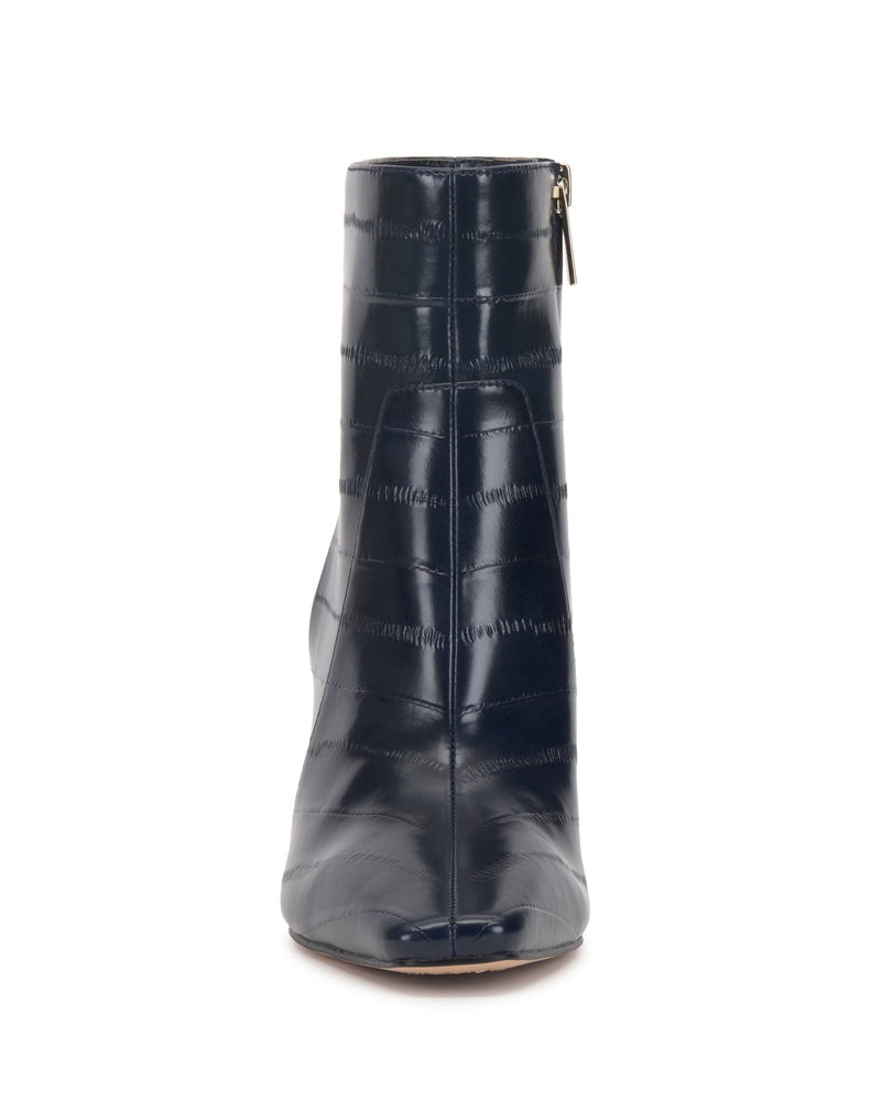 A front view of the navy blue Vince Camuto Bayla Bootie, an ankle-high boot featuring a glossy, textured finish and a convenient side zipper for effortless style.