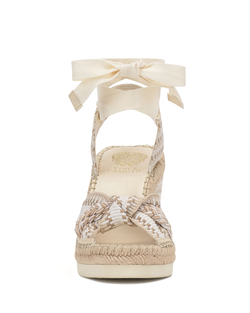 Front view of the Bealie Wedge Sandal by Vince Camuto in beige and cream, featuring braided straps, a textured platform sole, and a cream ankle tie bow closure.