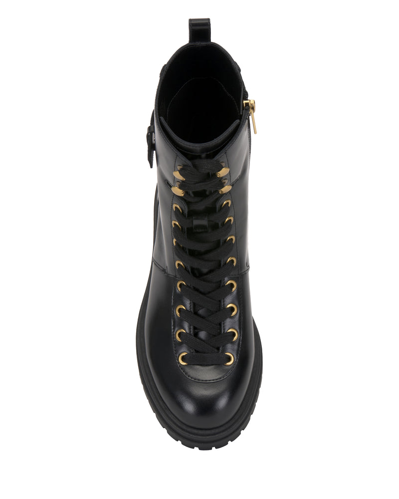 The Vince Camuto Becinda Moto Bootie is a black lace-up combat boot with gold eyelets, a chunky sole, and a side zipper, shown from an overhead view.