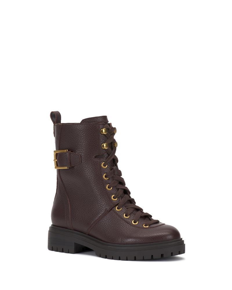 The Vince Camuto Becinda Moto Bootie features a dark brown leather design with gold eyelets, a lace-up front, side buckle detail, rugged sole, and a pull tab at the back.