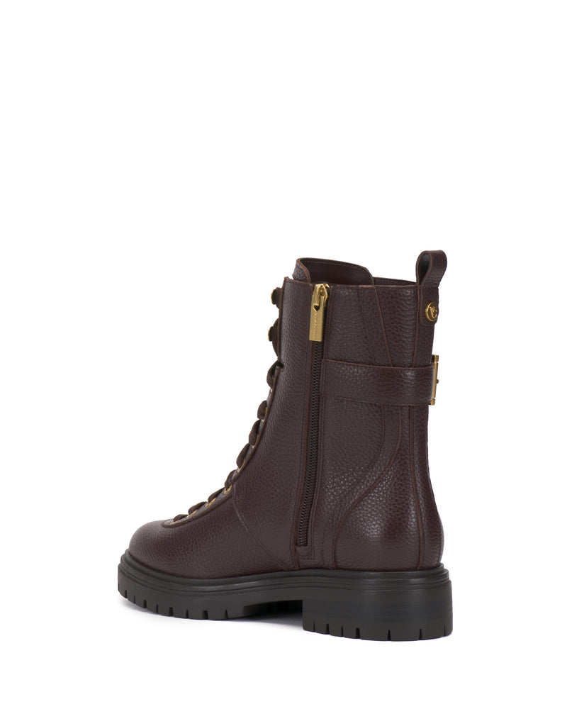 The Becinda Moto Bootie by Vince Camuto is shown at an angled rear view on a white background, featuring dark brown leather, a thick black sole, side zipper, lace-up front, and gold hardware.