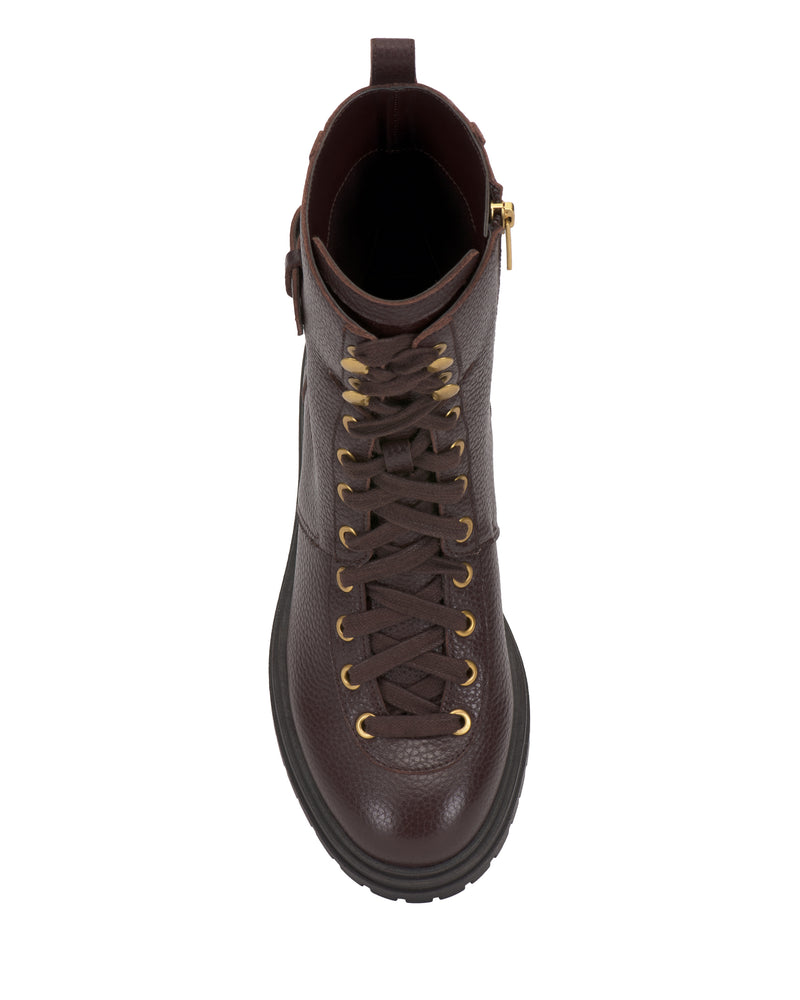 A top view of the Vince Camuto Becinda Moto Bootie, featuring dark brown leather, gold eyelets, brown laces, and a chunky black sole, shown against a white background.