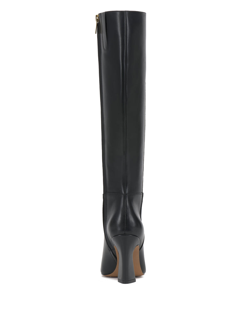 The Bennidy Narrow Calf Knee High Boot by Vince Camuto is a black leather boot with heels, shown from the back. It features a zipper on the upper side and has a brown sole.
