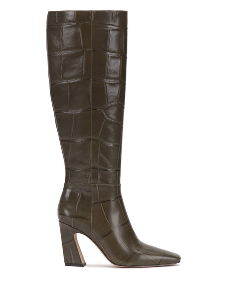 A knee-high Bennidy Extra Wide Calf Boot by Vince Camuto, crafted from dark olive faux-crocodile leather with a pointed toe and a chunky block heel, is shown in profile against a white background.