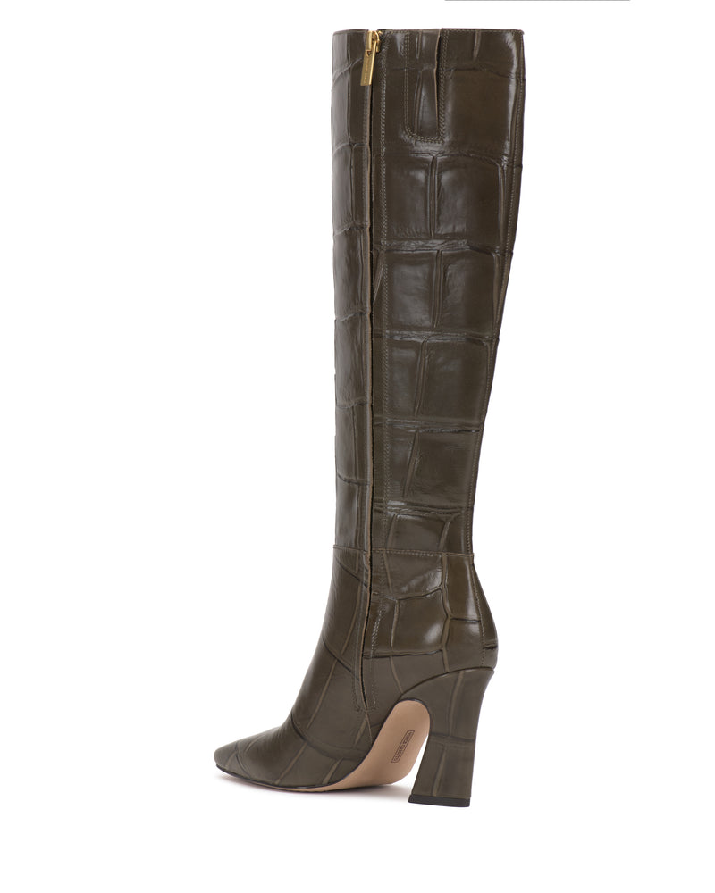 The Bennidy Extra Wide Calf Knee High Boot by Vince Camuto—a single, knee-high boot crafted in dark olive green crocodile-embossed leather with a pointed toe, side zipper, and block heel—is pictured in profile against a white background as an essential wardrobe staple.