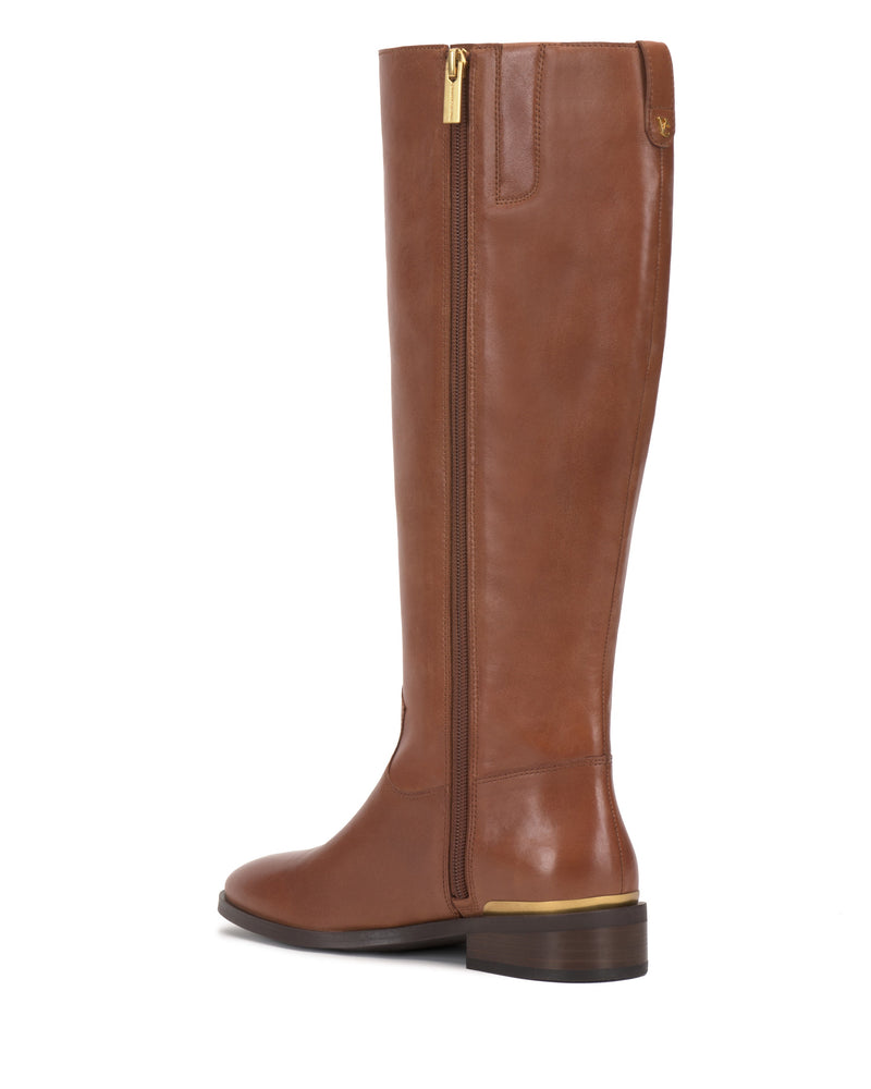 The Vince Camuto Bercla Knee High Riding Boot features tall brown leather with western styling, a low heel, gold-tone zipper, and gold heel accent, shown from a side-back angle.