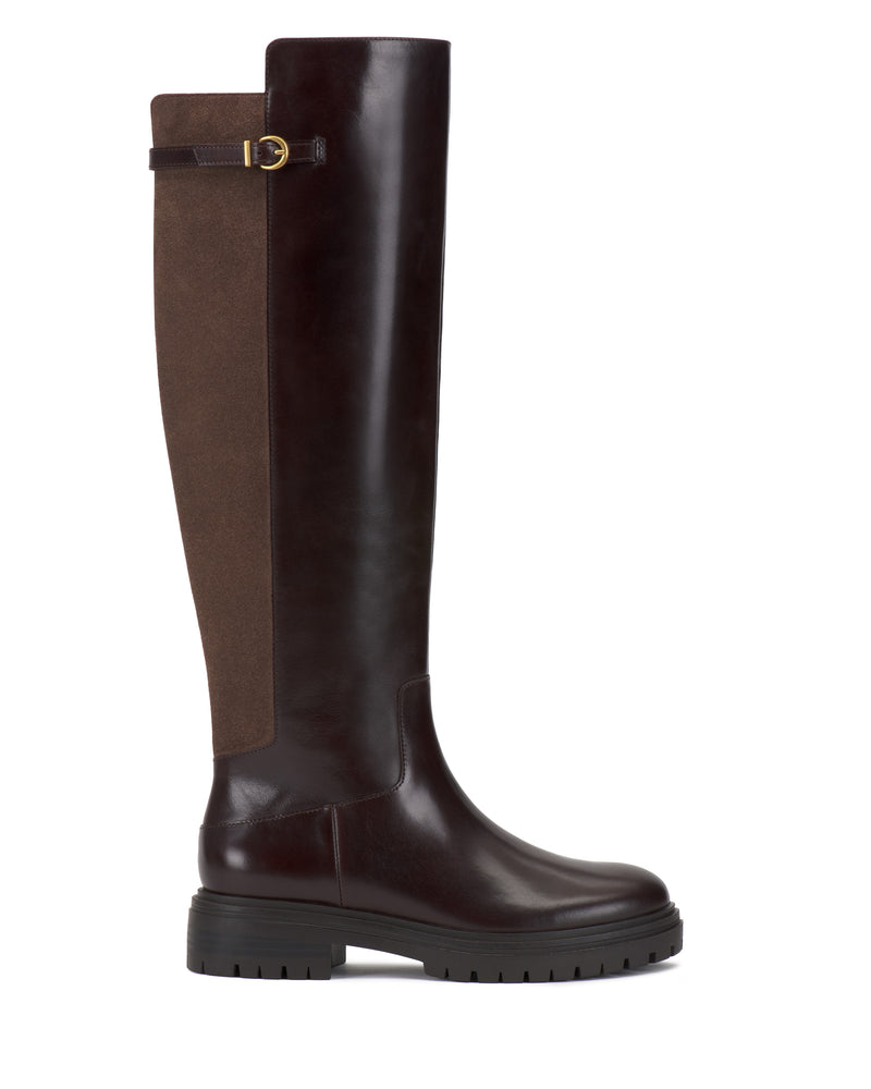 The Bertla Extra Wide Calf Knee High Riding Boot by Vince Camuto features a dark brown leather front, a brown suede back, a black chunky sole, and a strap with a gold buckle at the top.