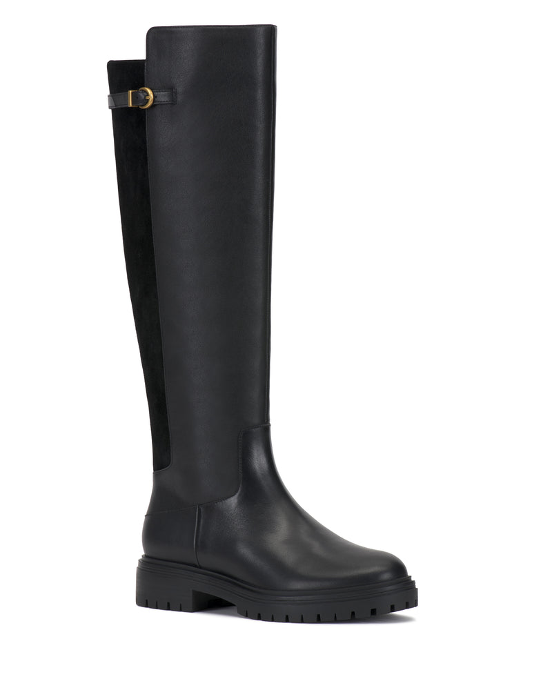 The Bertla Knee High Riding Boot by Vince Camuto is a tall black riding boot featuring a chunky sole, side buckle detail, and a contrast back panel.
