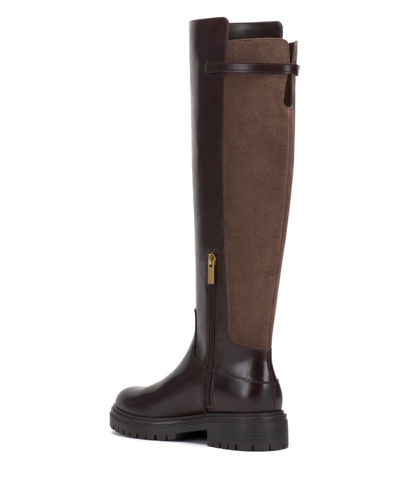 The Bertla Knee High Riding Boot by Vince Camuto features a tall silhouette with a dark brown leather front, brown suede back, convenient side zipper, and a thick ridged sole.