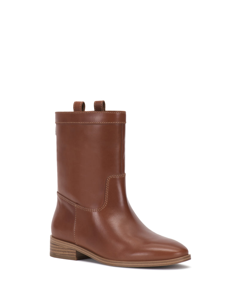 The Vince Camuto Bezzley Bootie is a single brown leather mid-calf boot featuring a low stacked heel, side stitching details, and pull tabs on top, displayed against a white background.