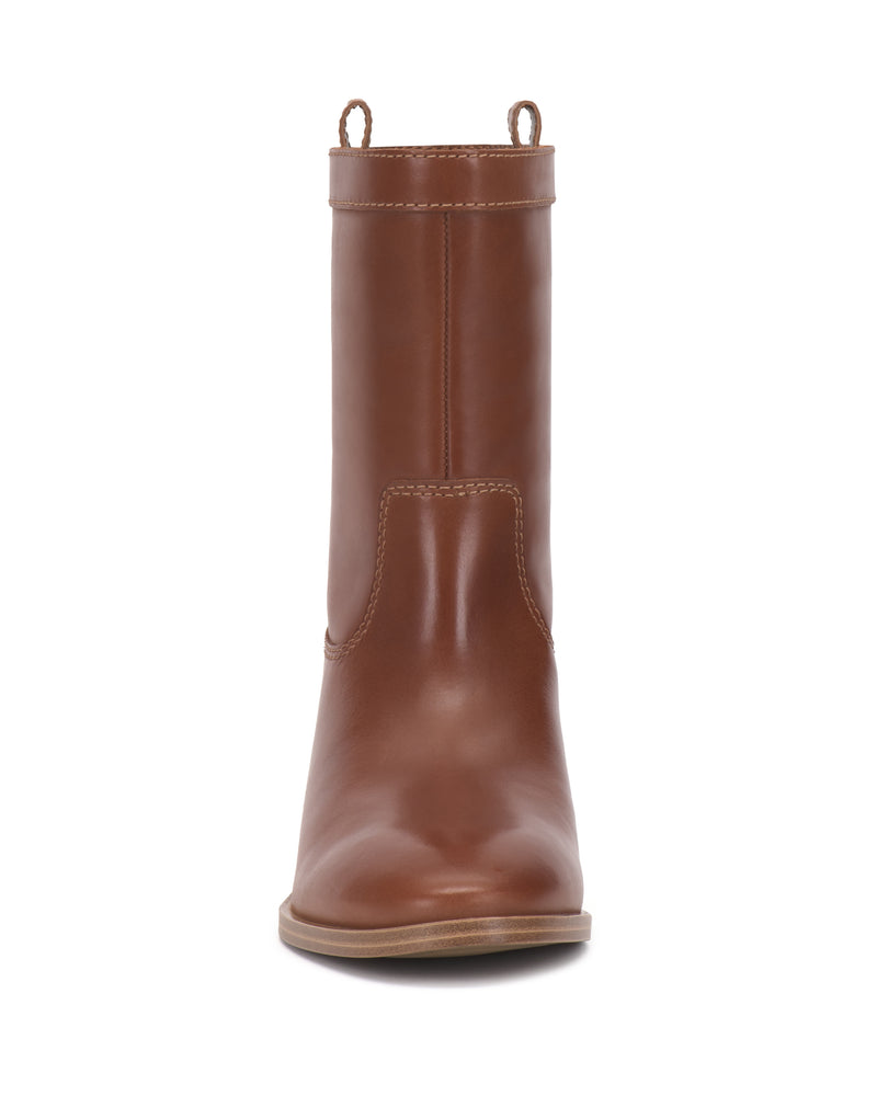 A front view of the Vince Camuto Bezzley Bootie, a single brown leather boot featuring a rounded toe, visible stitching, and pull tabs on both sides at the top. The sole is tan and flat.