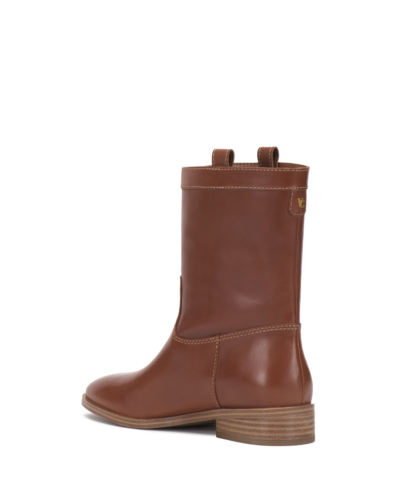 The Bezzley Bootie by Vince Camuto is a brown leather mid-calf boot featuring a low stacked heel, two pull tabs, and subtle stitching details, displayed from a side-back angle against a white background.