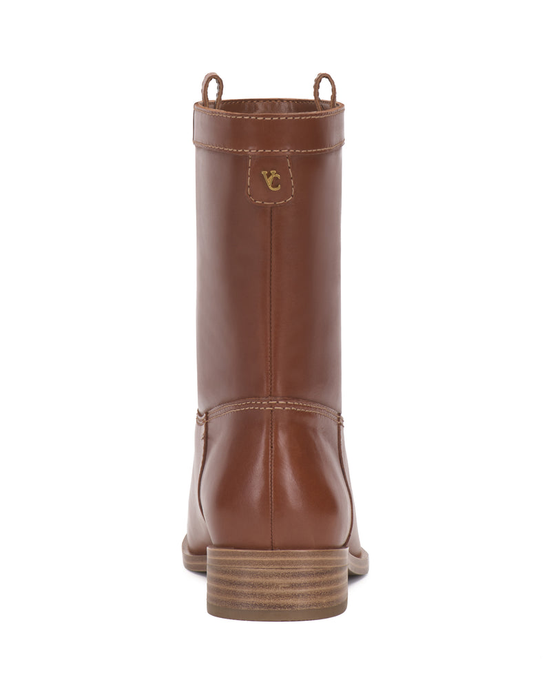 The Bezzley Bootie by Vince Camuto is shown from the back in brown leather, highlighting its visible stitching, short stacked heel, and a small logo on the upper heel.