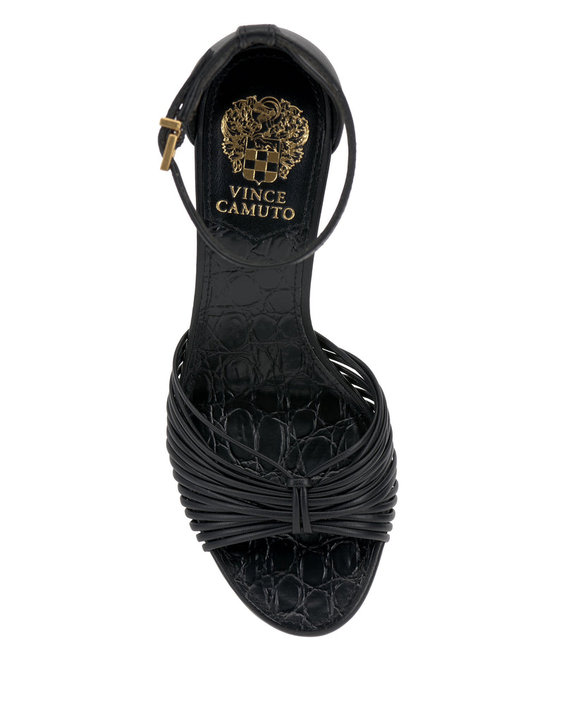 Top view of the Vince Camuto Blaine Sandal in black, featuring a textured crocodile-pattern footbed, gold logo on the insole, thin buckled ankle strap, and strappy open toe front with an elegant twisted design.