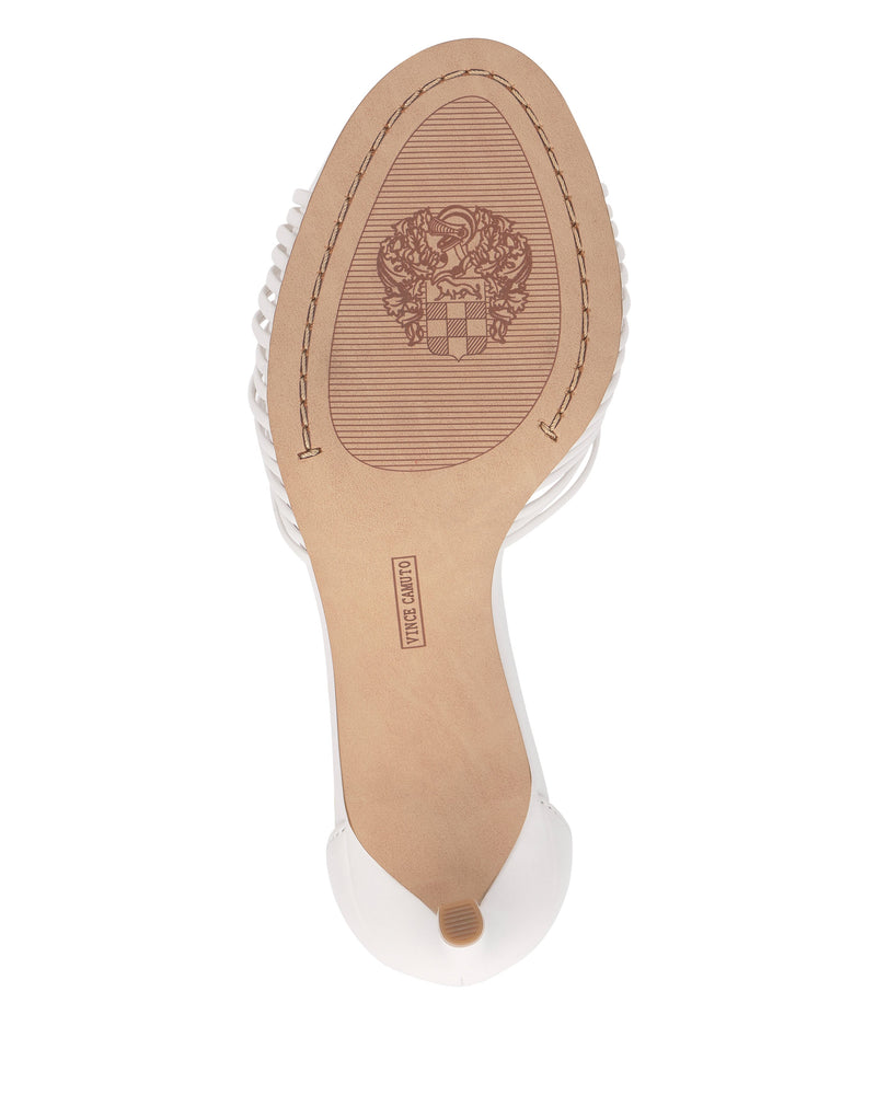 The image shows the sole of the Blaine Sandal by Vince Camuto—a white tall heel with a textured surface, a crest design near the center, and a “Made in China” stamp. The heel tip is visible at the bottom.