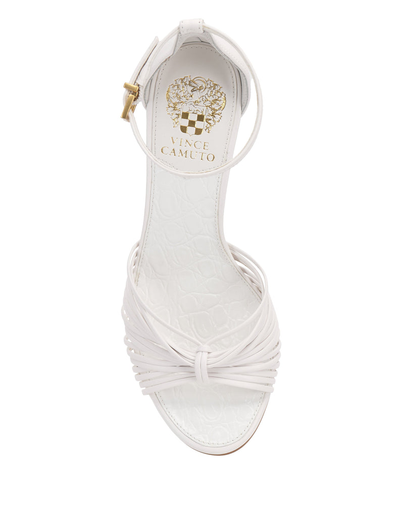 Top view of the Vince Camuto Blaine Sandal, a white women's strappy style with a woven toe strap, tall heel, ankle strap with buckle, and gold logo on the insole.