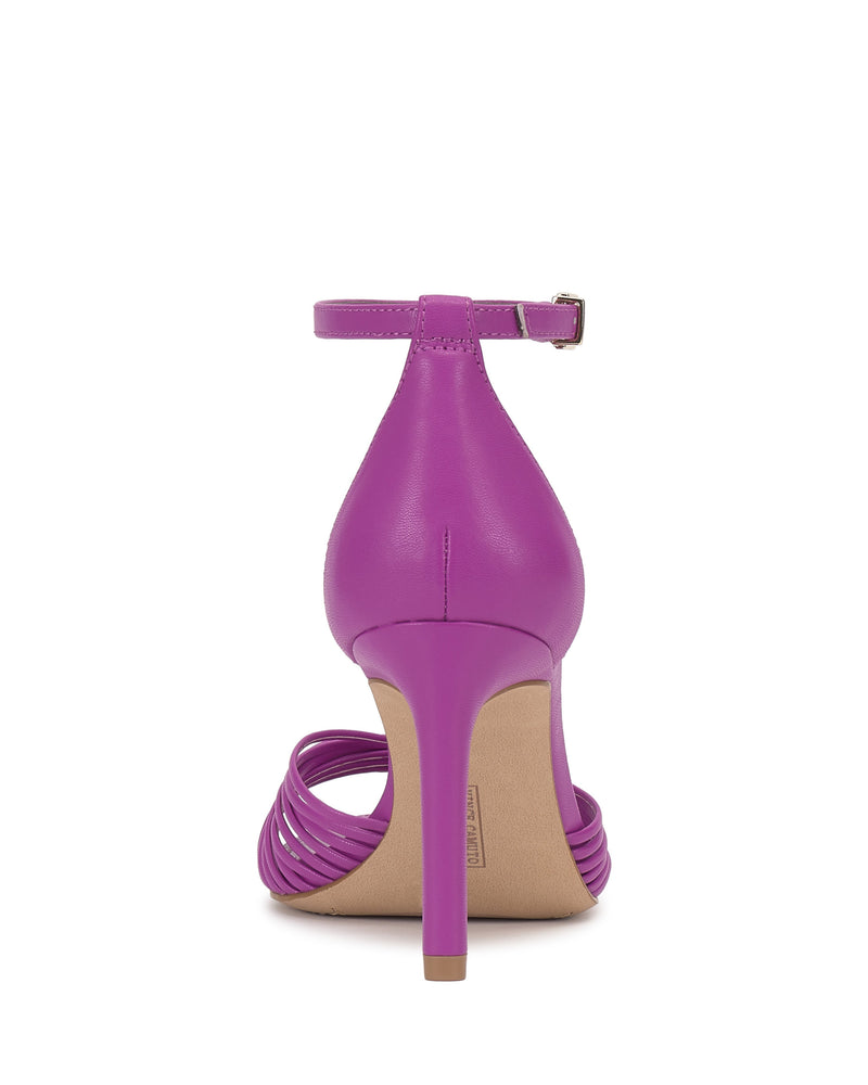 The Vince Camuto Blaine Sandal features a back view of a bright purple, reptile-embossed finish with skinny ankle strap and buckle, closed heel counter, strappy open toe, tall heel, and beige sole and heel tip.