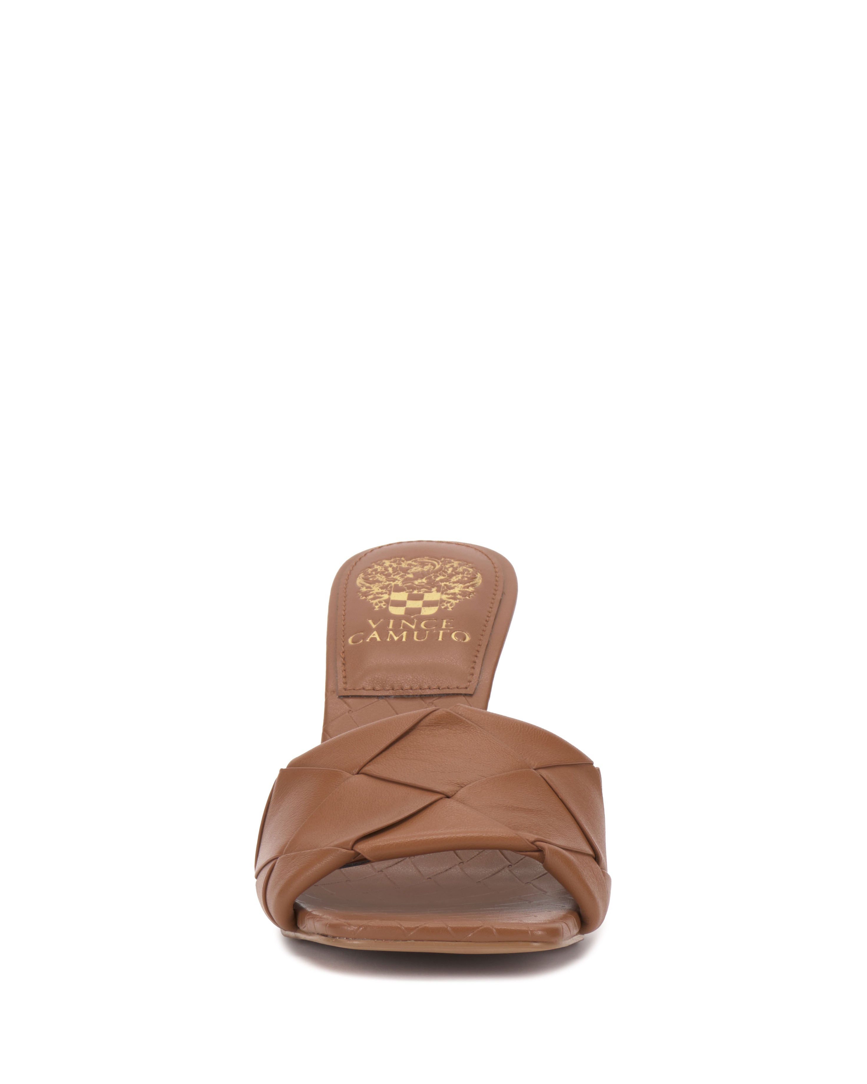 Front view of the Brelanie Woven Mule by Vince Camuto, a brown basketweave leather slide sandal with open toe and gold Vince Camuto logo printed on the insole.
