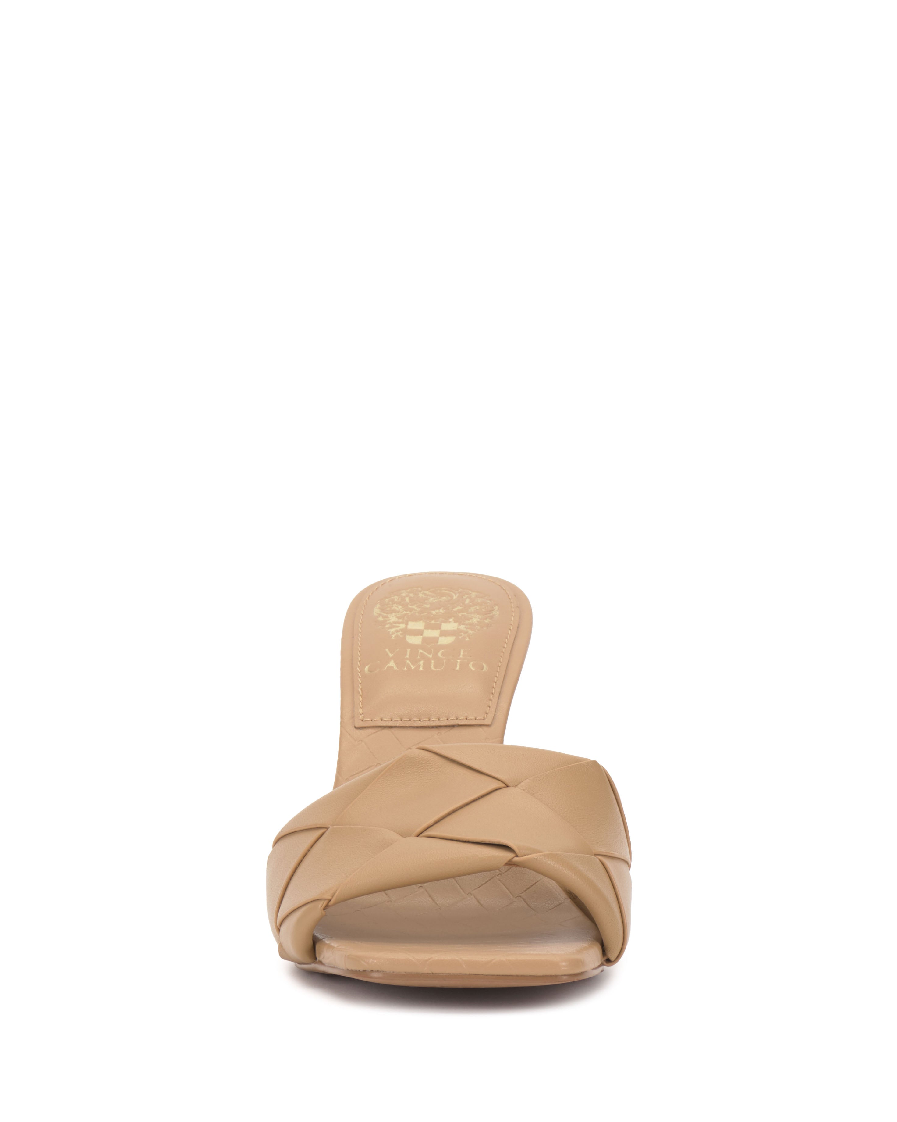 Front view of the Brelanie Woven Mule by Vince Camuto, a beige open-toe slip-on sandal with a basketweave leather upper, low heel, and cushioned insole featuring a gold Vince Camuto logo for an elegant touch.