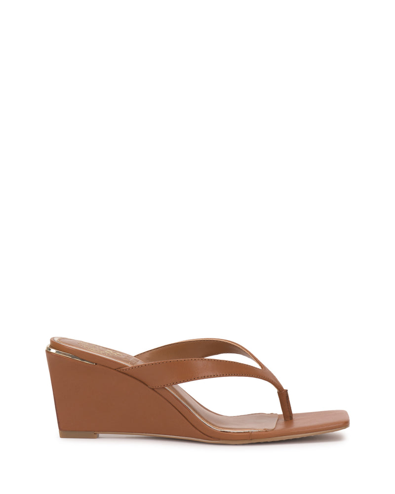 The Cianna Wedge Sandal by Vince Camuto features a brown medium-height wedge, open toe, thong toe with single strap, and offers a minimalist, modern look.